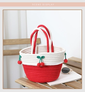 Close-up of handmade red and white cotton rope woven handbag with crochet cherry charms