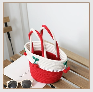 Detail of handmade woven cherry bag with red accents and delicate lace trim on wood