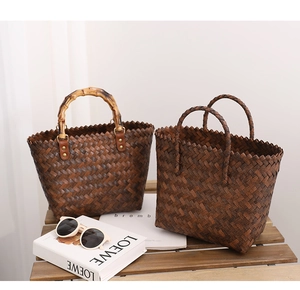 Close-up of brown woven tote bags with bamboo handles and detailed straw texture