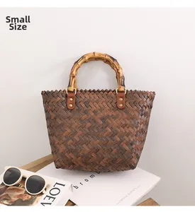 Close-up of small woven straw tote with bamboo handles and chic leather stitching detail