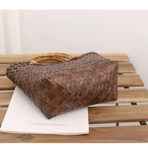 Close-up of a dark brown woven tote bag featuring a vintage bamboo handle and texture