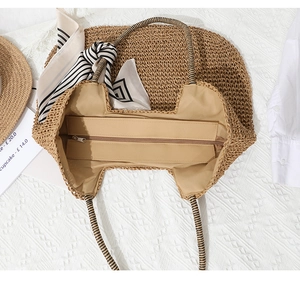 Detail of woven straw tote bag with zipper closure and striped rope handles