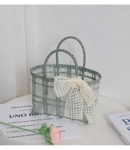 Detail of light green checkered woven basket with lace bow in a French pastoral style