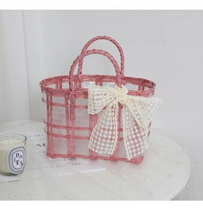 Pink and white woven tote bag featuring a decorative lace bow and double handles
