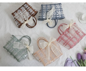 Detailed top view of handmade plaid woven tote bags in five pastel colors with lace bows