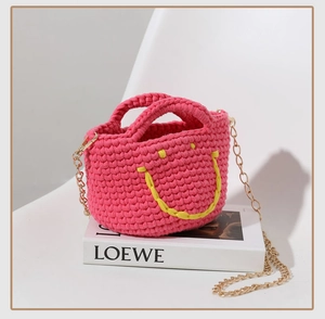 Vue détaillée du mini sac cabas rose crocheté à la main avec motif smiley jaune