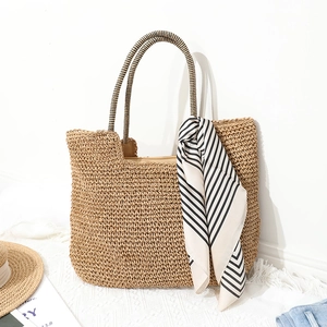 Large hand-woven straw tote bag with black and white striped handles for summer beach beach