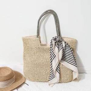 Large woven straw tote bag with black and white striped handles and matching scarf accent