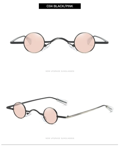 Close-up of retro round steampunk sunglasses with black metal frame and pink lenses