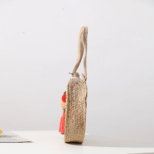 Handmade round straw shoulder bag with colorful pompom tassels and woven straps