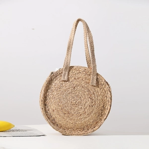 Large circular woven straw handbag with dual shoulder straps for beach vacation use