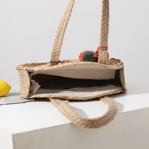 Handmade round straw tote bag with pompom decor and large capacity interior view