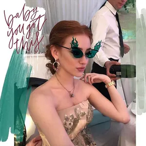 Detail of trendy flame-shaped sunglasses with green lenses and slim metal frames