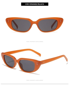 Detail view of vintage orange cat-eye sunglasses with silver rivets and grey lenses