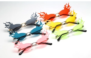 Flat lay of rimless flame-shaped sunglasses in six vibrant colors with metal temples
