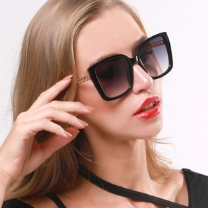 Dettaglio di occhiali da sole cat-eye con stanghette in metallo traforato oro rosa e lenti