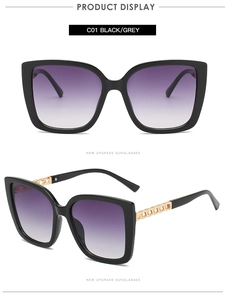 Dettaglio occhiali da sole cat-eye con lenti sfumate viola e stanghette a catena dorata