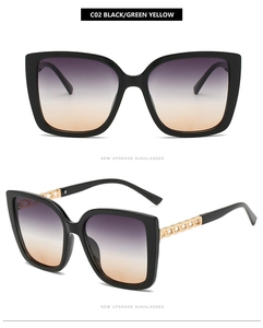 Dettaglio occhiali da sole cat-eye con stanghette dorate e lenti sfumate viola