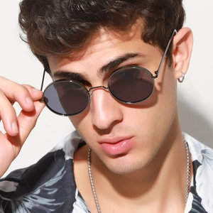 Close-up of retro round metal sunglasses with detailed floral texture on black frames