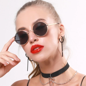Detail shot of vintage round sunglasses with slim metal temples on a female model