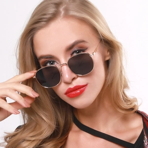 Close-up of model wearing retro small square metal sunglasses with dark grey lenses