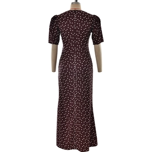 Detail view of burgundy polka dot maxi dress featuring a rear zipper and fishtail hemline