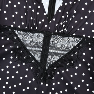 Detail of V-neckline with black lace patchwork and hidden zipper on polka dot dress