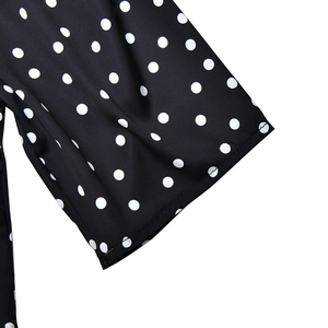 Detailed view of polka dot dress cuffs with premium double stitching on black fabric