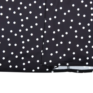 Close-up of black fabric with white polka dots and high-quality hemmed edge stitching