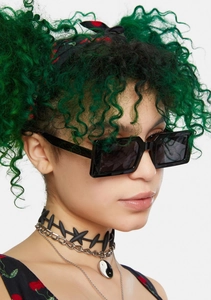 Detail of black rectangular thick frame sunglasses worn with street style jewelry