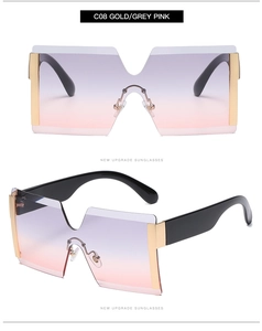 Detail of oversized rimless square sunglasses with grey-pink gradient lenses and gold metal frame