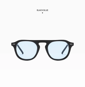 Close-up of black pilot sunglasses with blue tinted lenses and metal stud details