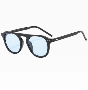 Detail of vintage double-bridge sunglasses featuring black frames and light blue lenses