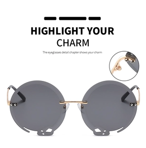 Detail der runden Sonnenbrille mit goldenem Metallrahmen und Cut-Out Design auf den Gläsern