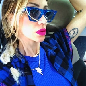 Lunettes de soleil œil de chat bleues et collier doré à pendentifs étoile et éclair