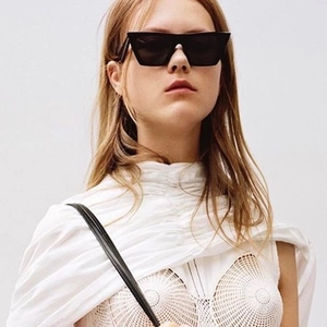 Mannequin portant des lunettes de soleil carrées noires avec une monture géométrique chic