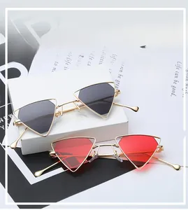 Detailed view of punk triangle sunglasses with gold metal frames and gray or red lenses