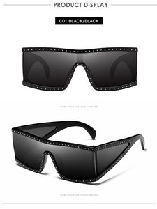 Detail of black oversized sunglasses with silver rivet accents and flat top design