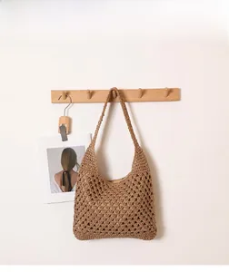 Détail d'un grand sac cabas en paille tissée avec des motifs ajourés en crochet de style bohème
