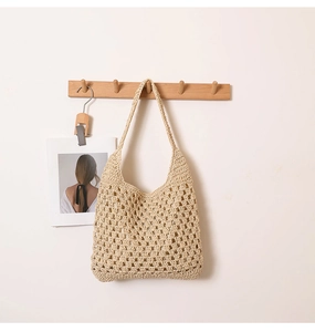 Détail de la texture en maille ajourée d'un sac à bandoulière en paille beige