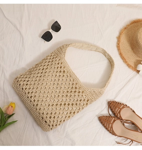 Détail du motif au crochet ajouré et de la texture tressée du sac de plage en paille