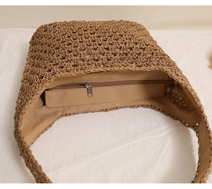 Vue détaillée du sac en paille tressée avec poche intérieure zippée et doublure naturelle