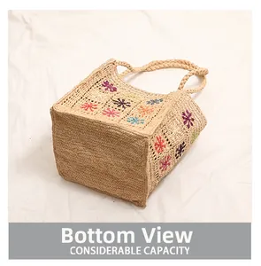Dettaglio borsa in rafia intrecciata con ricami colorati e fondo quadrato capiente