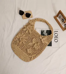 Detail der hohl gewebten Strohtasche mit 3D-Häkelblumen für den Strandurlaub am Meer