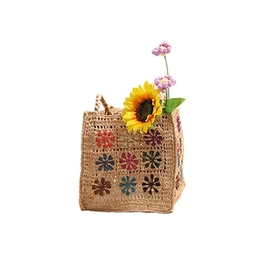 Borsa da spiaggia in rafia bohémien con motivi floreali all'uncinetto su sfondo bianco