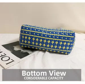 Detail view of the reinforced bottom of the blue and yellow striped woven beach tote bag