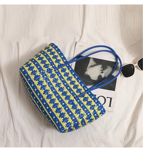 Detail view of woven tote bag with blue and yellow stripe texture and round handles