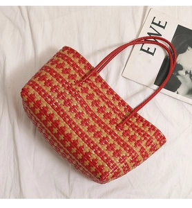 Detailed cross-weave pattern of the red and khaki plastic woven tote beach bag