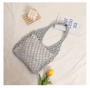 Detail of silver metallic woven straw bag with hollow out pattern for beach vacation