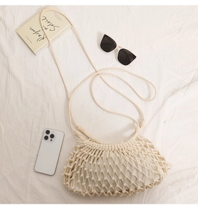 Detail of white macrame crossbody bag showing intricate woven patterns and fabric lining